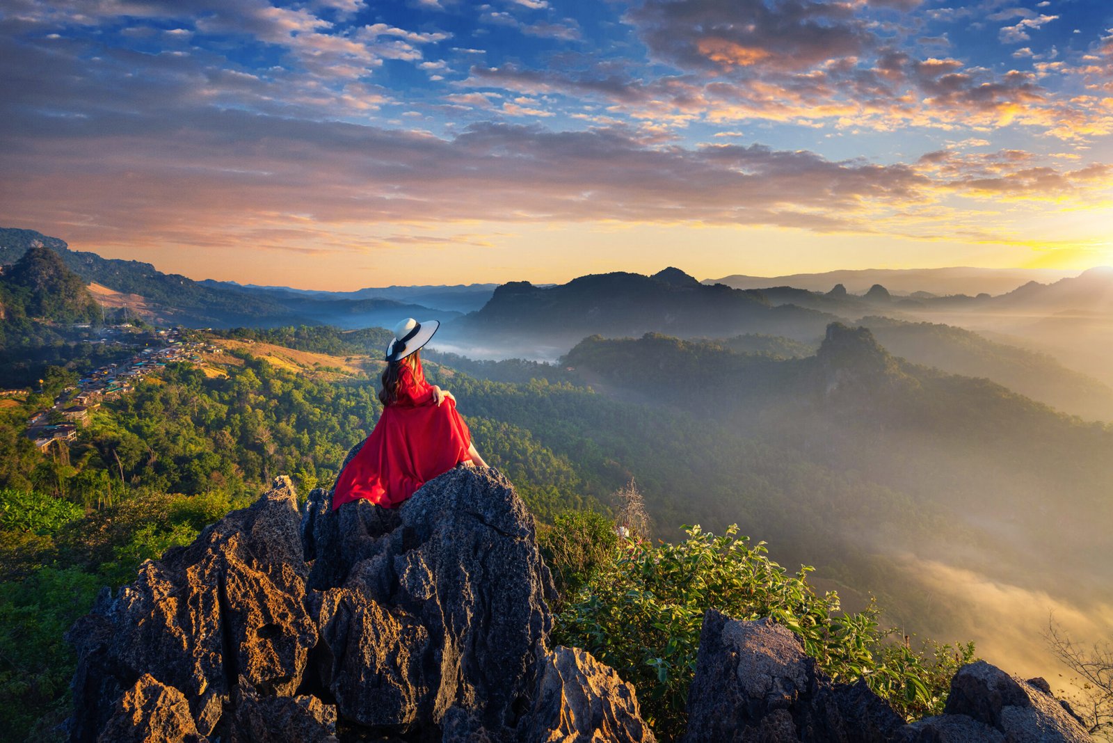 Beautiful girl sitting on sunrise viewpoint at Ja Bo village, Mae hong son province, Thailand.